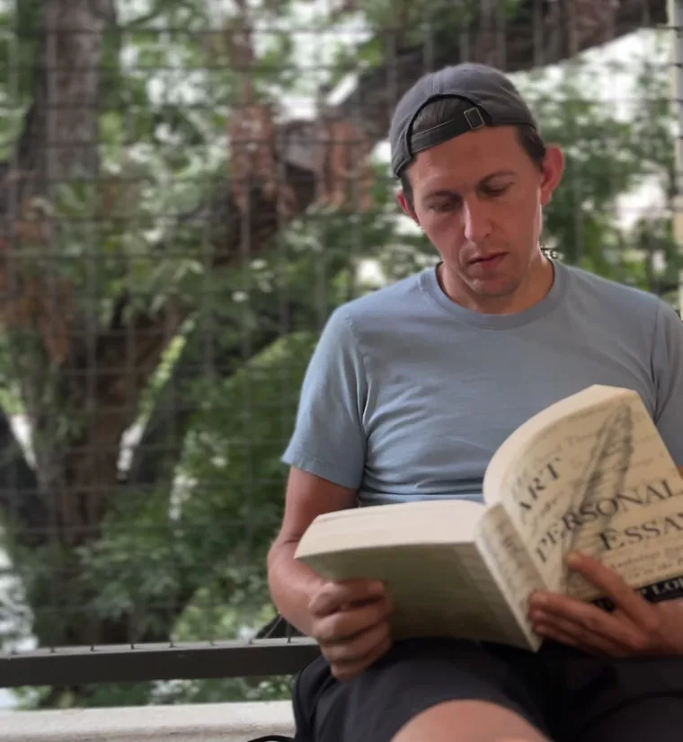 Paul reading a book outside