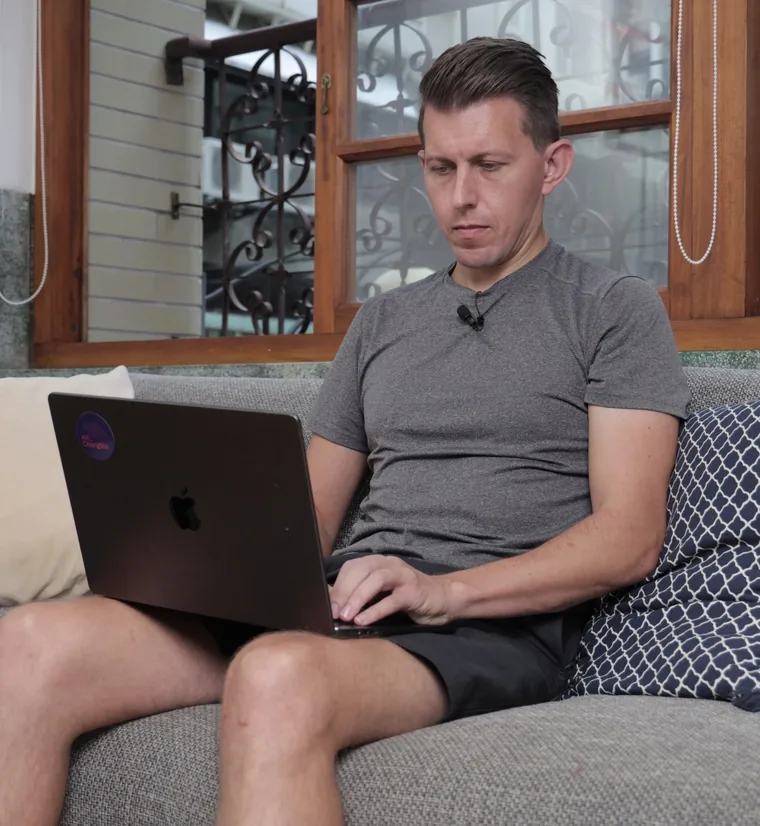 Paul writing on his laptop on the couch